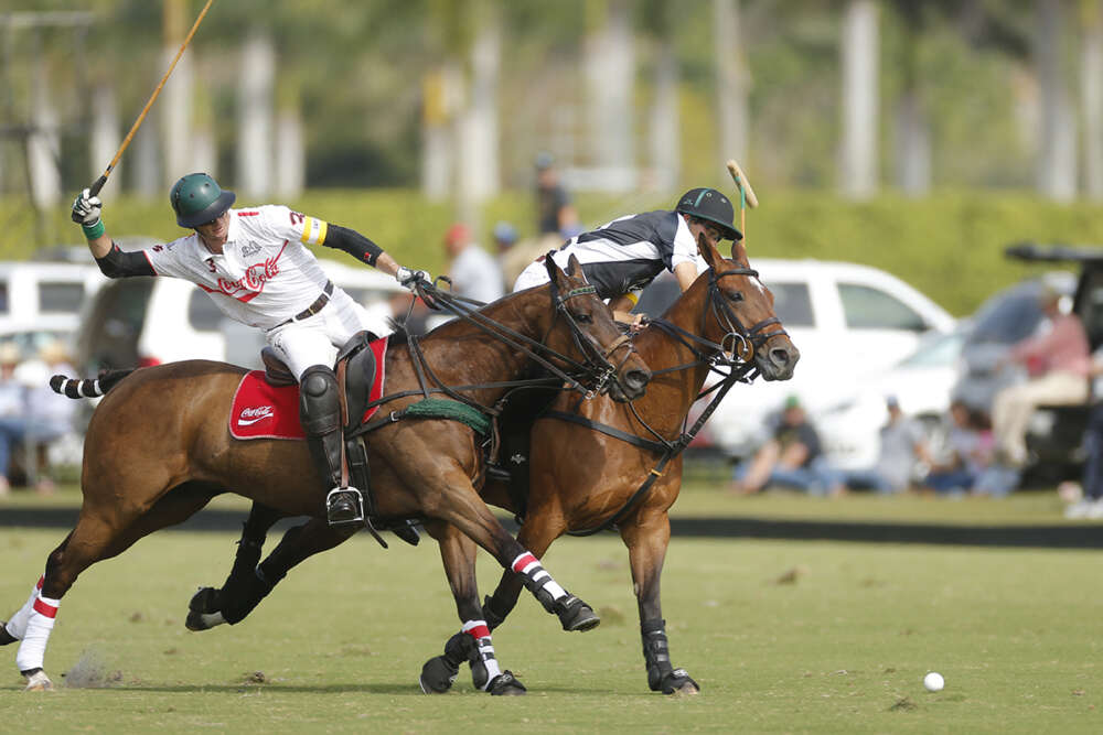 Modere's Hilario Ulloa takes the ball on the nearside as Coca-Cola's Julio Arellano rides in to defend. 