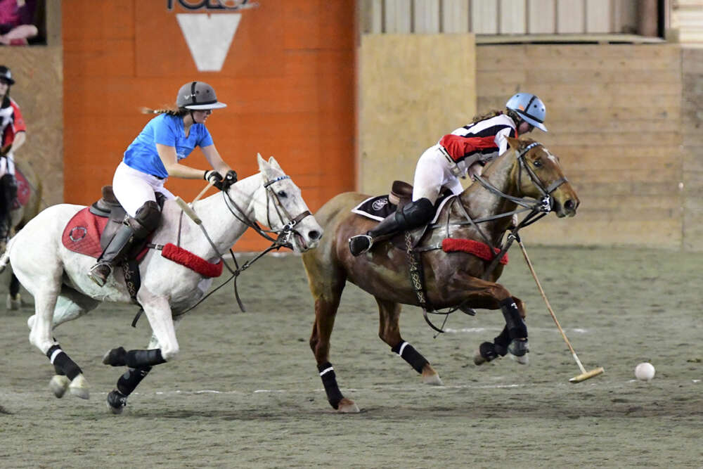 Maryland Polo Club's Maddie Grant carries the ball down the arena on the nearside, Central Coast Polo Club's Petra Teixeira on defense. 